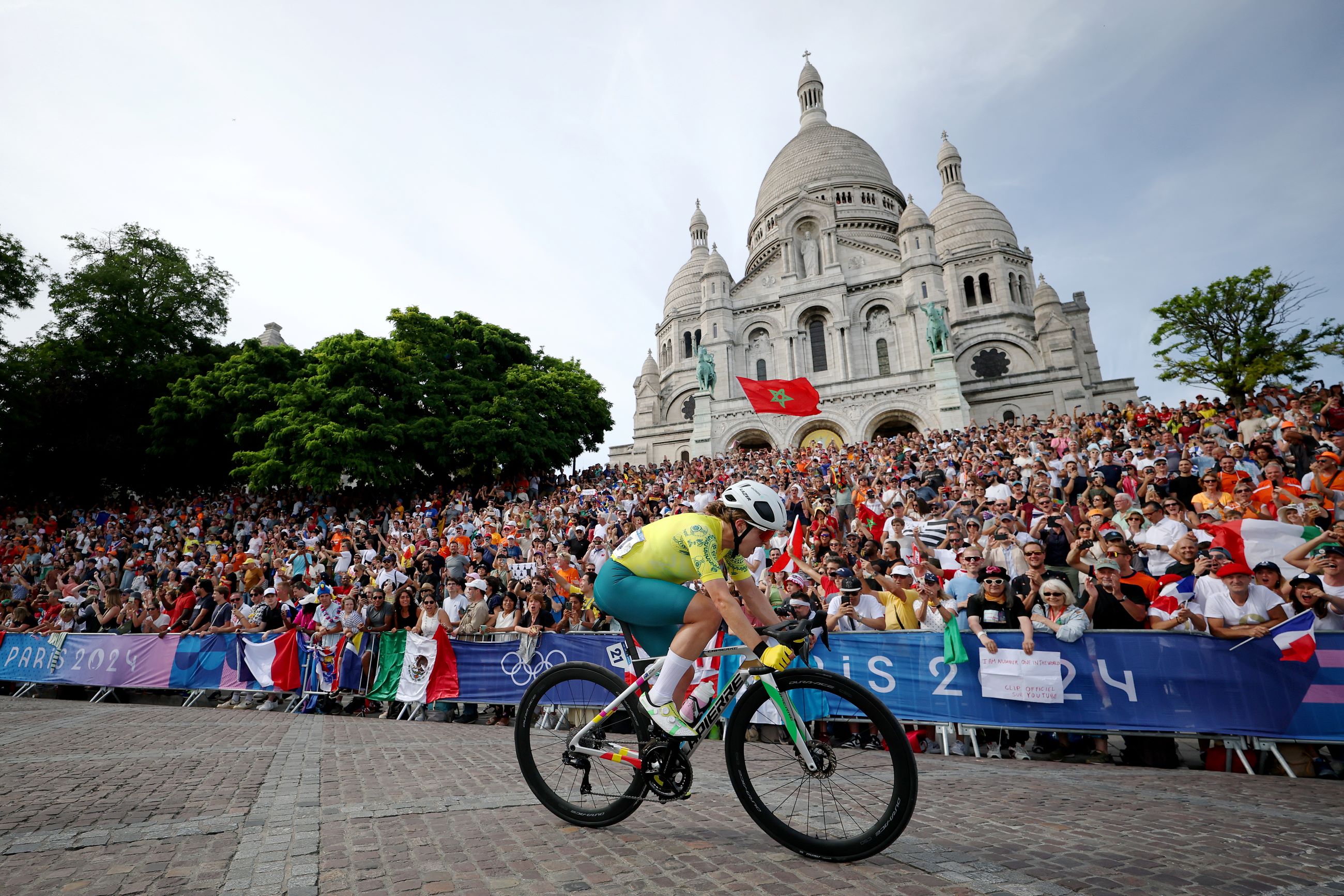 Australian road cyclist Grace Brown passes a crowd of cheering spectators beneath the Sacre Coeur basilica in Paris, France during the 2024 Paris Olympic Games women's road race